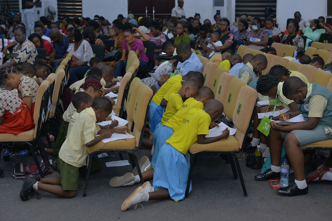 Participants and accompanying adults seated in the hall.