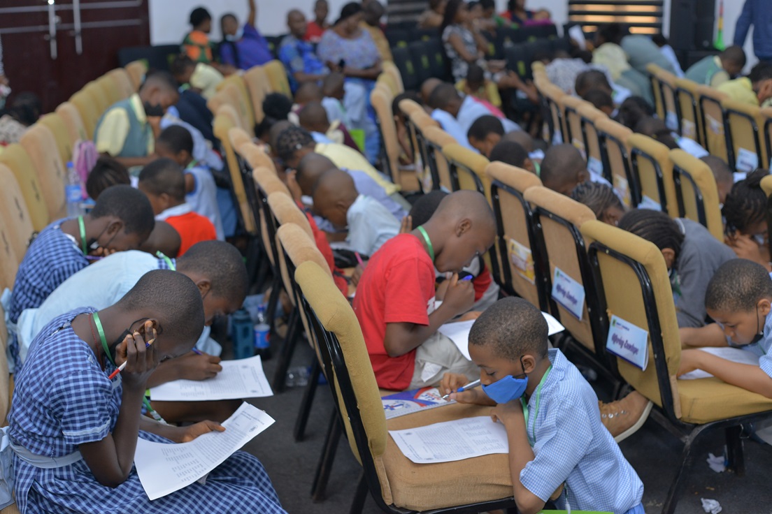Participants working on papers in rows of seats.